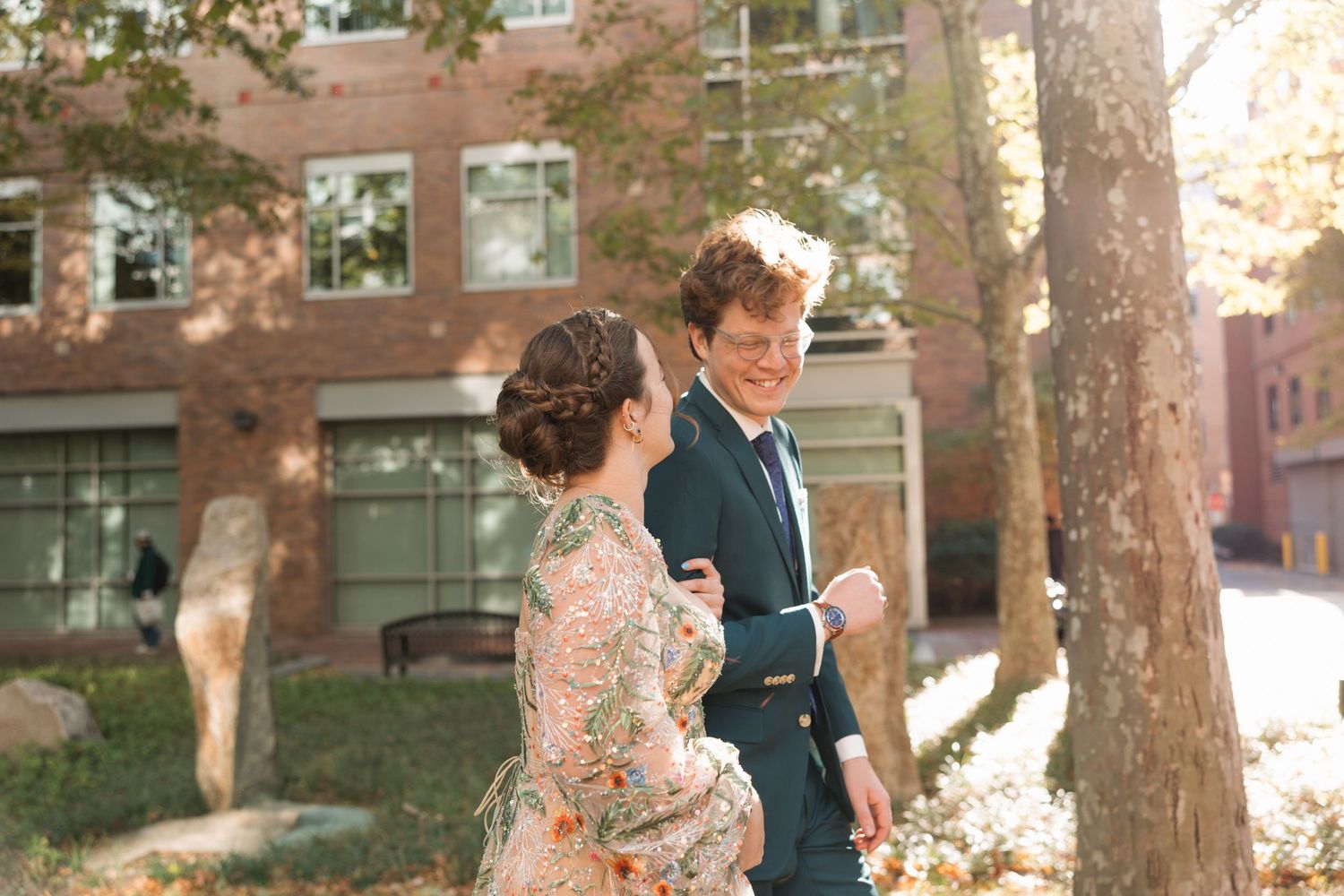 Couple walking together and smiling during an intimate wedding day in warm afternoon light.